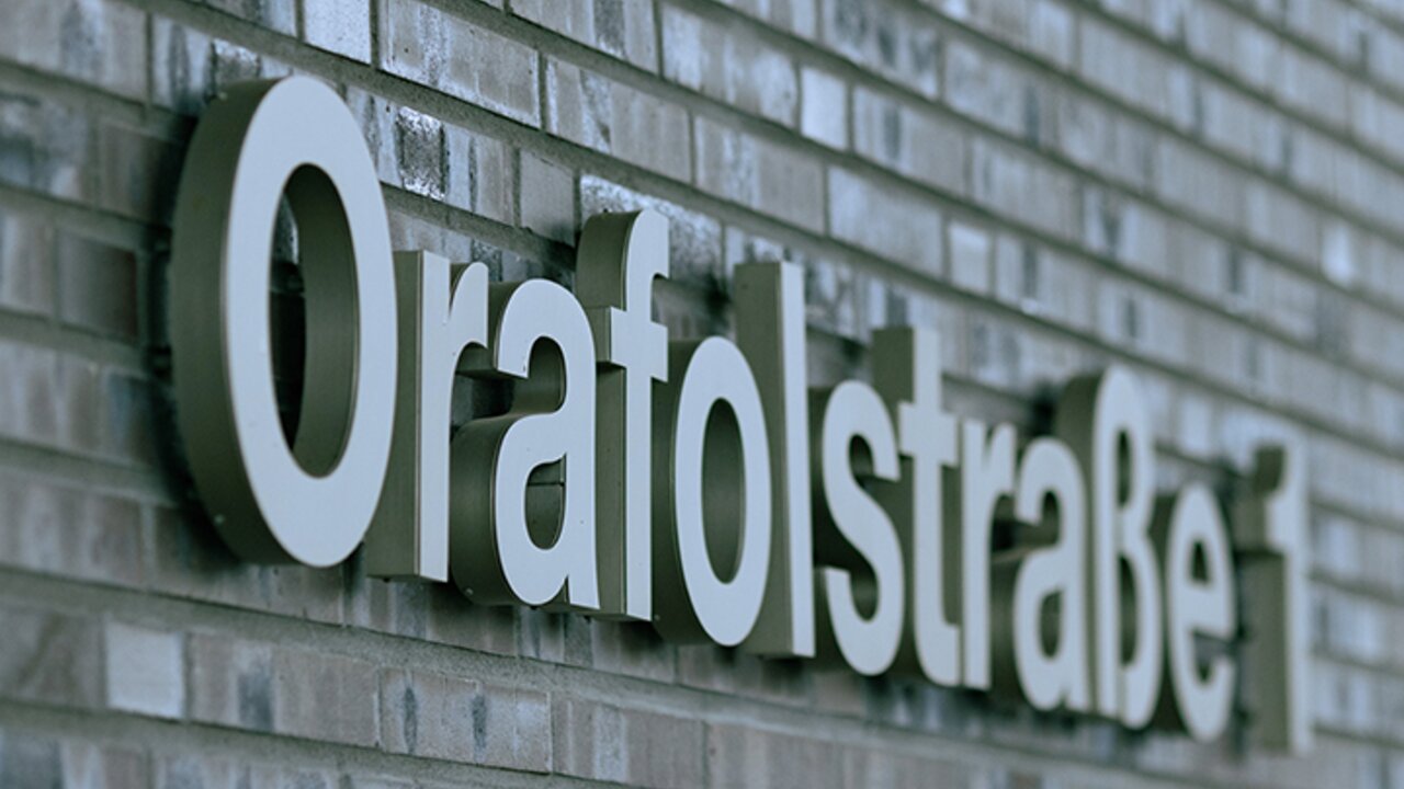 Nahaufnahme eine grau-braunen Klinker-Backsteinmauer, die den Schriftszug "Orafolstraße 1" trägt. 